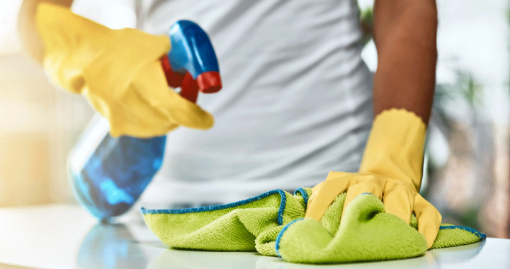 A person cleaning and disinfecting COVID-19 germs on their counter.