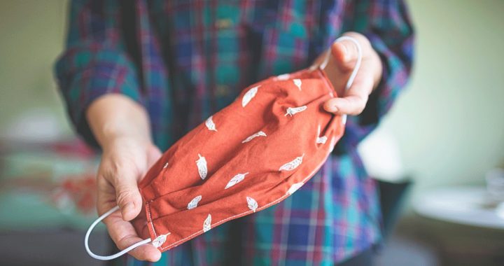 A person holding a homemade cloth face covering