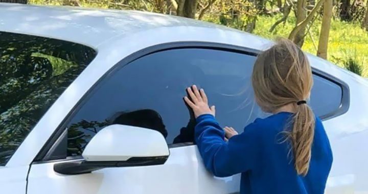 Carly and Briggs having a social distance visit during COVID-19 using a car window.