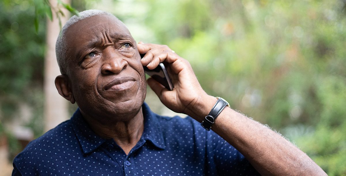 A man on the phone with hospital staff advocating for a loved one