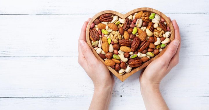 A photo of heart healthy nuts in a heart-shaped bowl.