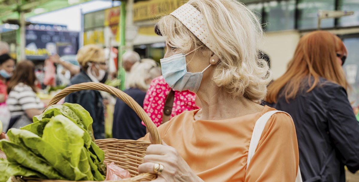 A woman wearing a face mask to a farmers market during COVID-19.