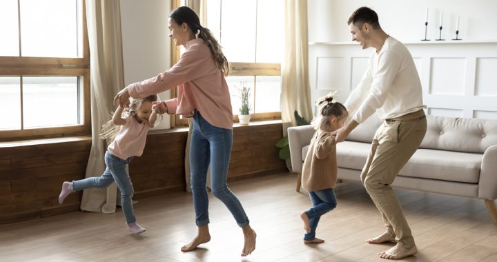 Parents and kids having a dance party together in their living room.