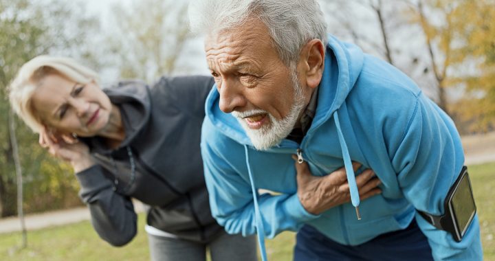 A man experiencing one of the early signs of a heart attack: chest pain.