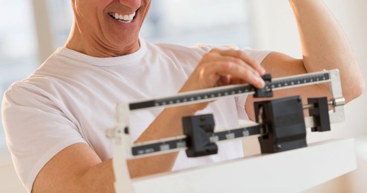 A man checking his weight on a scale.