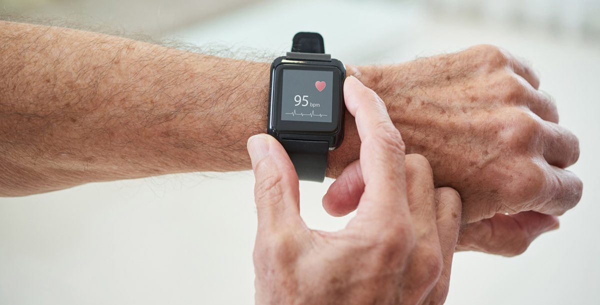 A person checking their heart rate using a smart watch.