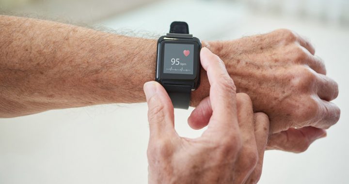 A person checking their heart rate using a smart watch.